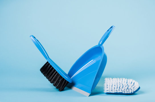 Cleaning concept - dustpan and sweeper on blue gradient backdrop