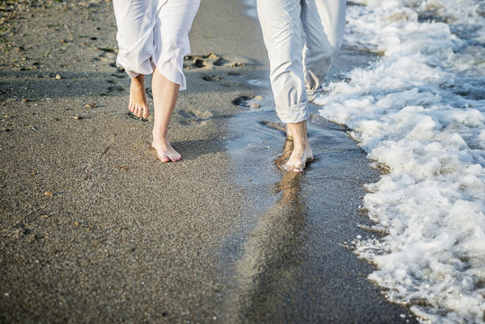 Legs of couple on the sand beach