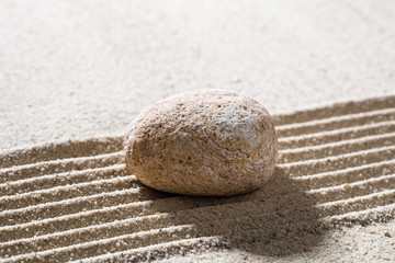 Fototapeta na wymiar zen sand still-life - textured pebble on straight lines for concept of concentration or tranquillity.
