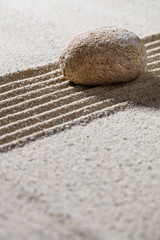 Fototapeta na wymiar zen sand still-life - textured pebble on straight lines for concept of meditation or progression, closeup.