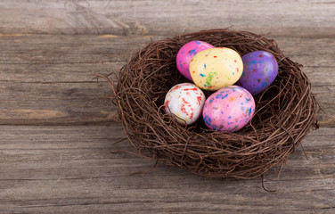 Easter Candy Eggs in a Nest on a Rustic Wooden Surface