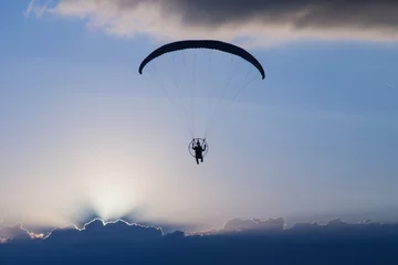Tableaux sur verre Sports aériens Silhouette paramotor / paraglider flying on sky.