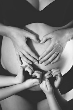 Pregnant belly and hearts from hands