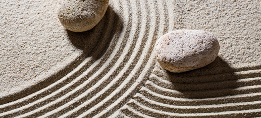 zen zand stilleven - twee stenen over lijnen om verschillende richtingen te geven voor het concept van verschil of evolutie met vrede, bovenaanzicht
