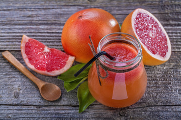 freshly squeezed juice of red grapefruit on a wooden table
