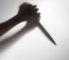 Silhouette of someone holding knife,blur image