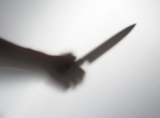Silhouette of someone holding knife,blur image