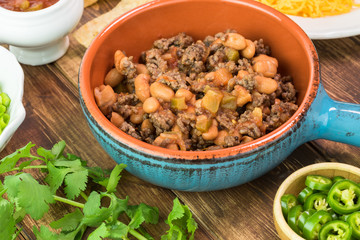 Ingredients for homemade nachos. Bowl with mixed beef and pinto beans.