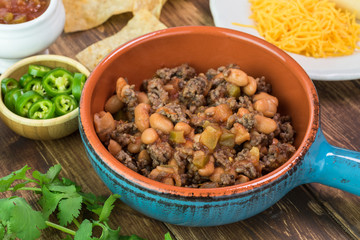 Ingredients for homemade nachos. Bowl with mixed beef and pinto beans.