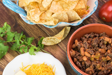 Ingredients for homemade nachos. Bowl with mixed beef and pinto beans.