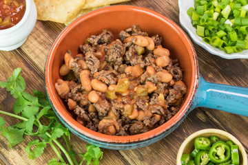 Ingredients for homemade nachos. Bowl with mixed beef and pinto beans.