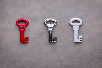 three keys red silver and white on grey background