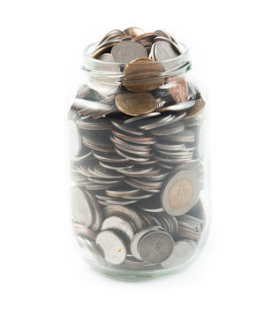coins in a glass jar against a white background