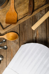 Chef hat and wooden spoons on wooden table