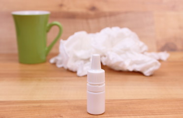 Fototapeta na wymiar Nose drops for colds, used handkerchiefs and hot tea