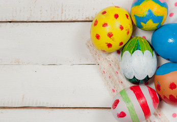Easter eggs and hay on wooden background