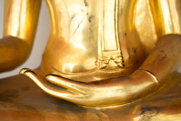 Left Hand of Old Gold Buddha statue sit cross legged.
