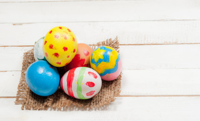Easter eggs and hay on wooden background