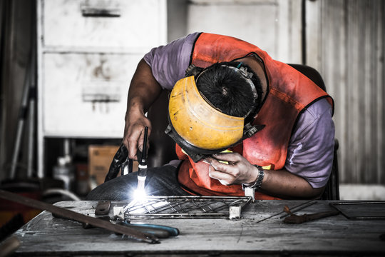 HDR image of a technician using tig welder in factory's workshop