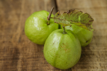 Closeup Three Ripe Green Guavas on Brown Table