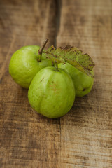 Closeup Three Ripe Green Guavas on Brown Table