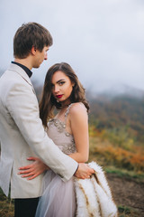 happy newly married couple posing in the mountains