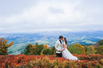 happy newly married couple posing in the mountains
