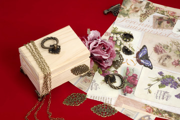 Making decoupage jewelry box - tools and materials on red velvet background