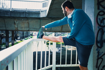 Young man stretching his body after workout and jogging.