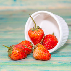 strawberries in bowl on wood background