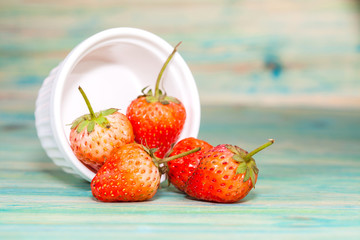 strawberries in bowl on wood background