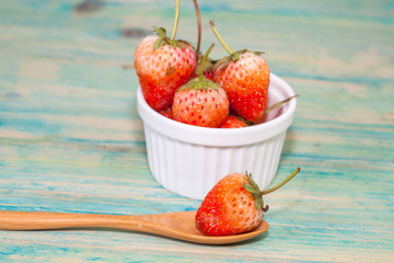 strawberries in bowl on wood background