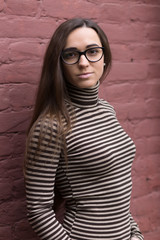 Woman wearing fashionable clothing against a brick wall background