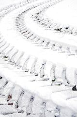 Tracks of car tires in defrosted snow 