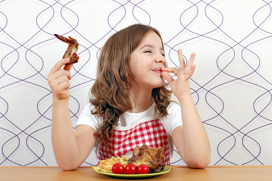 happy little girl with chicken wings and ok hand sign