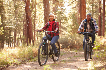 Senior Couple Cycling Through Fall Woodland