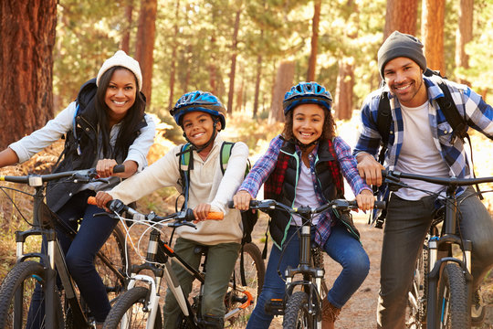 Portrait Of Family Cycling Through Fall Woodland