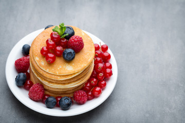 Stack of pancakes with blueberry and fresh berry.