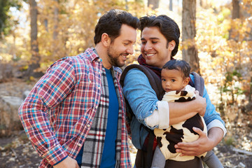 Smiling couple with daughter walking in forest