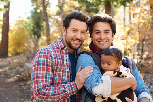 Gay Male Couple With Baby Walking Through Fall Woodland