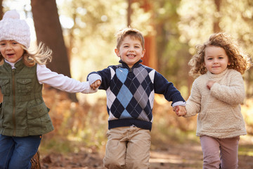 Fototapeta premium Group Of Young Children Running Along Path In Autumn Forest