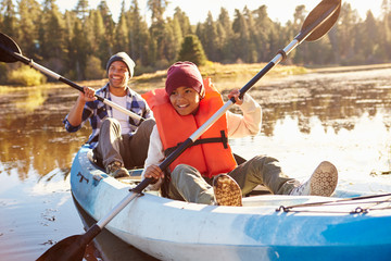 Father And Son Rowing Kayak On Lake