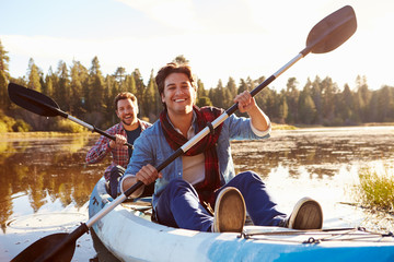 Male Gay Couple Rowing Kayak On Lake Together