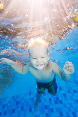 Fototapeta na wymiar Boy swims underwater