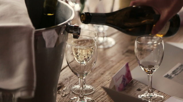 Waiter pours foaming champagne close up. Wedding celebration in Paris