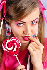 Beautiful girl with creative makeup with colorful lollipop
