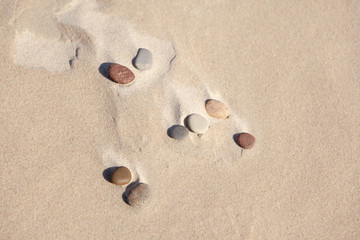 Fototapeta na wymiar stones on the sand by the sea, sea sand