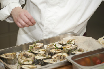 On a black skillet cooked pieces of fish, sturgeon.