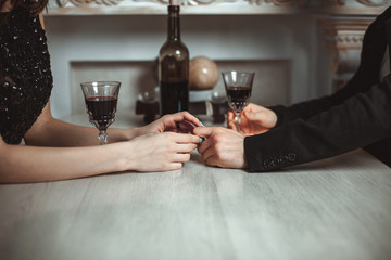 Beautiful young couple with glasses of red wine in luxury restaurant