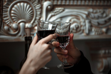 Beautiful young couple with glasses of red wine in luxury restaurant